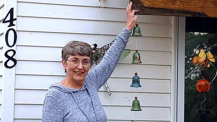 Research study participant Michelle Archibald hangs some homemade wind chimes while enjoying full range of motion in her left arm after recovering from elbow surgery.