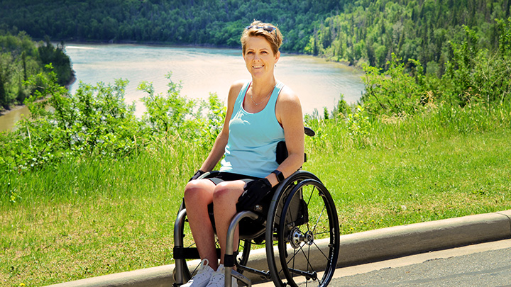 woman smiling sitting in wheelchair active outdoors