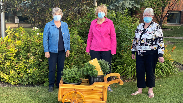 Members of the Auxiliary to the Lacombe Hospital and Care Centre — from left, Marianne Gustafson, president, Kathy Medd, treasurer and Dawn Atkinson, vice president — pose with a handcrafted cedar cart made by local resident Don Gustafson for the winner of the group’s annual raffle.