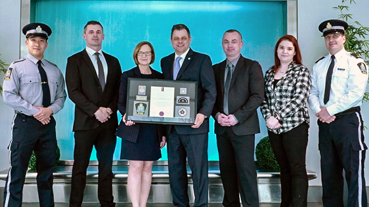 Members of AHS’ Protective Services team accept the Gold Lifesaving Award from representatives of St. John Ambulance Alberta. At the ceremony, from left, are: Robert Kung, Provincial training specialist and peace officer; Ryan Cammidge, director, Protective Services, Edmonton Zone; Beverly Lafortune, president and CEO, St. John Ambulance Alberta; Jerry Scott, chief protective services officer, senior programming officer, Protective Services; Grant Blaine, director, Protective Services Business Standards & Operational Support; Stacey Savage, manager of Training and Community Services at St John Ambulance Alberta; and Ryan Stratton, manager, Protective Services Training and Development Unit.